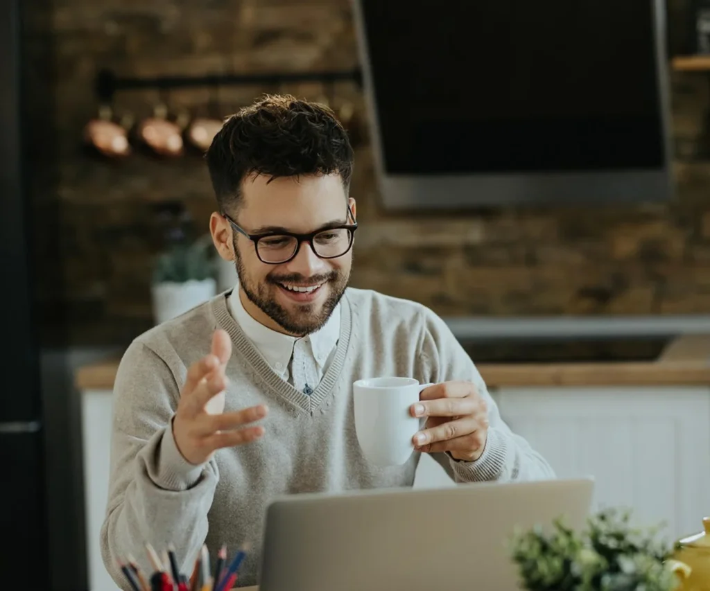 Hombre tomando café en una reunión online